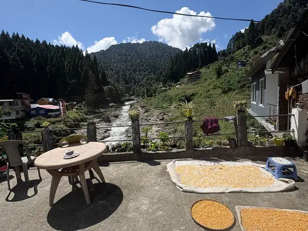 Terrace of Eden Homestay with a table, looking over the river and forest